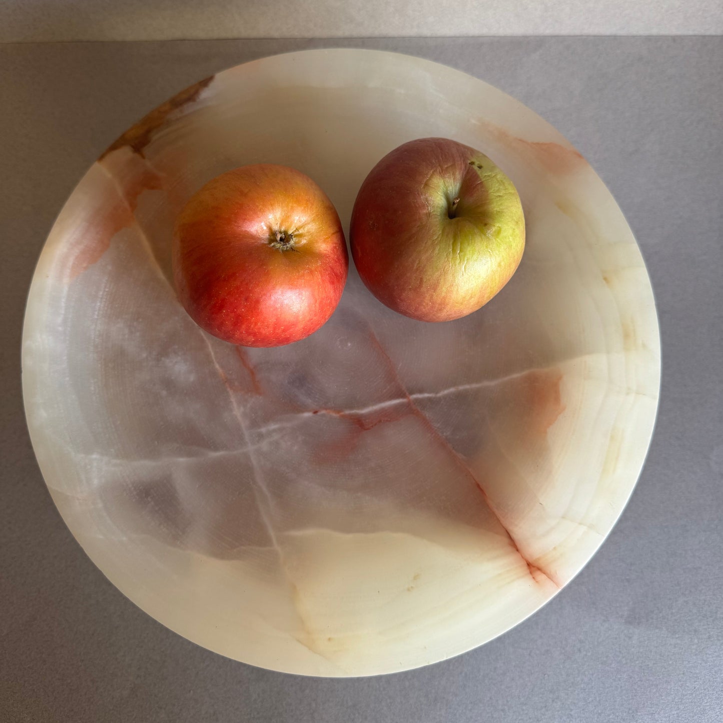 Stone pedestal bowl used for fruit display, with semi-translucent onyx catching the light