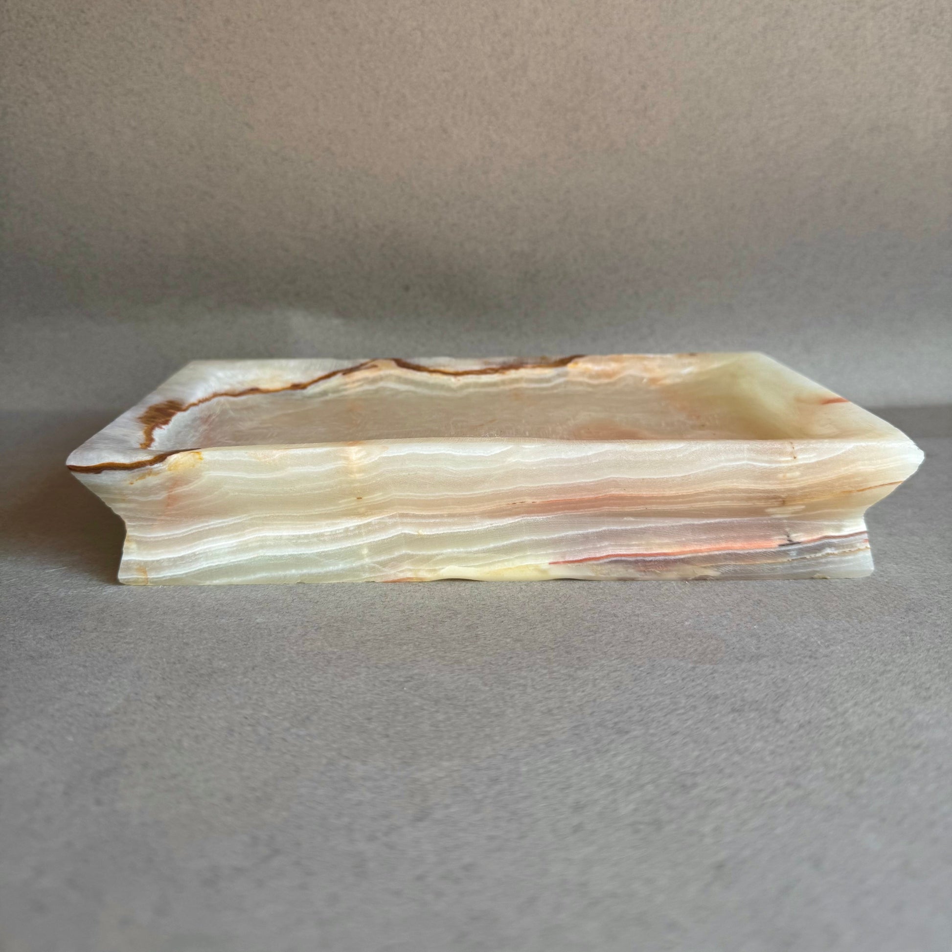 Rectangular onyx stone bowl on a gray background