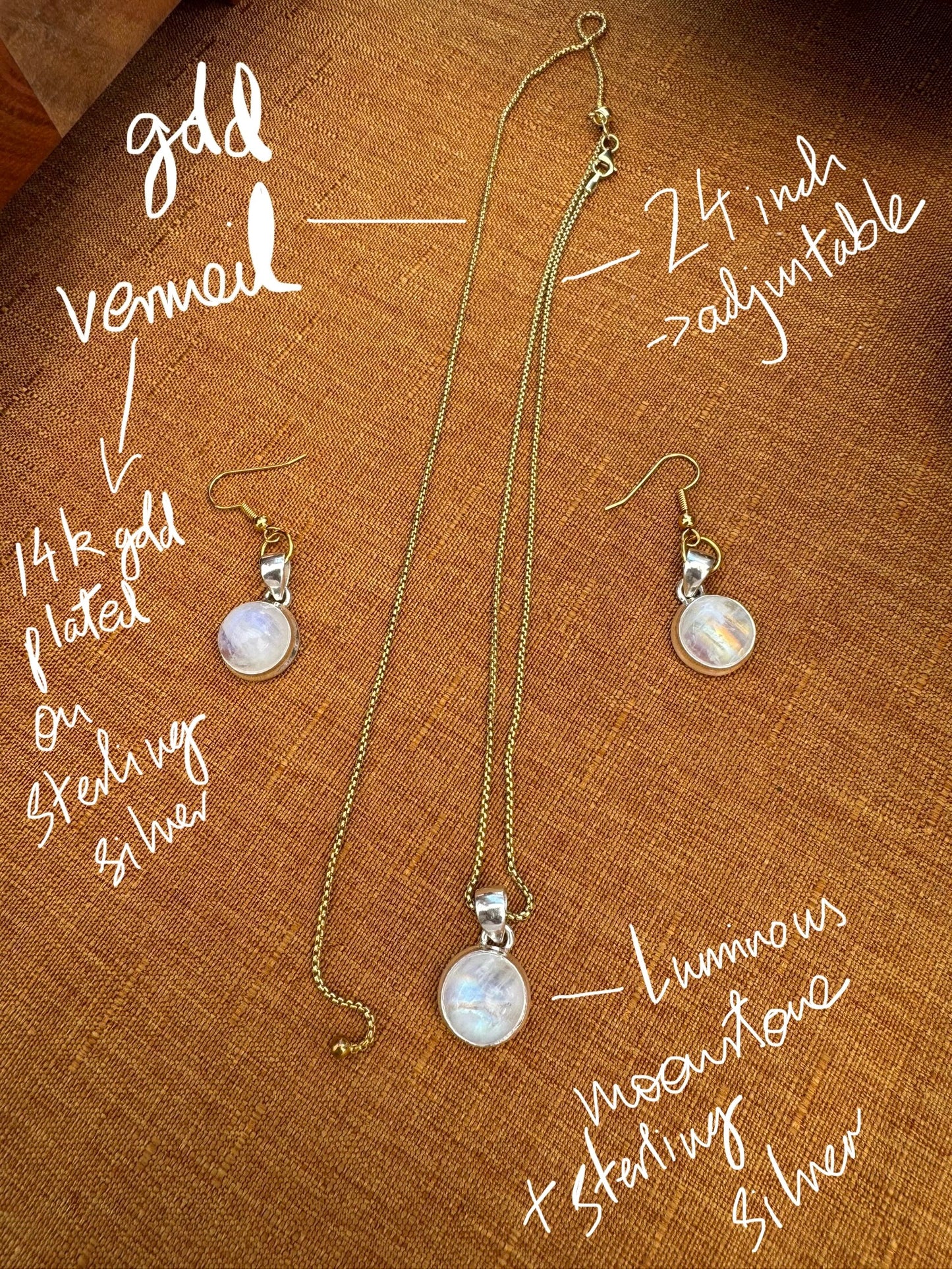 Gold vermeil moonstone pendant necklace and earrings on a brown fabric background with text describing features.