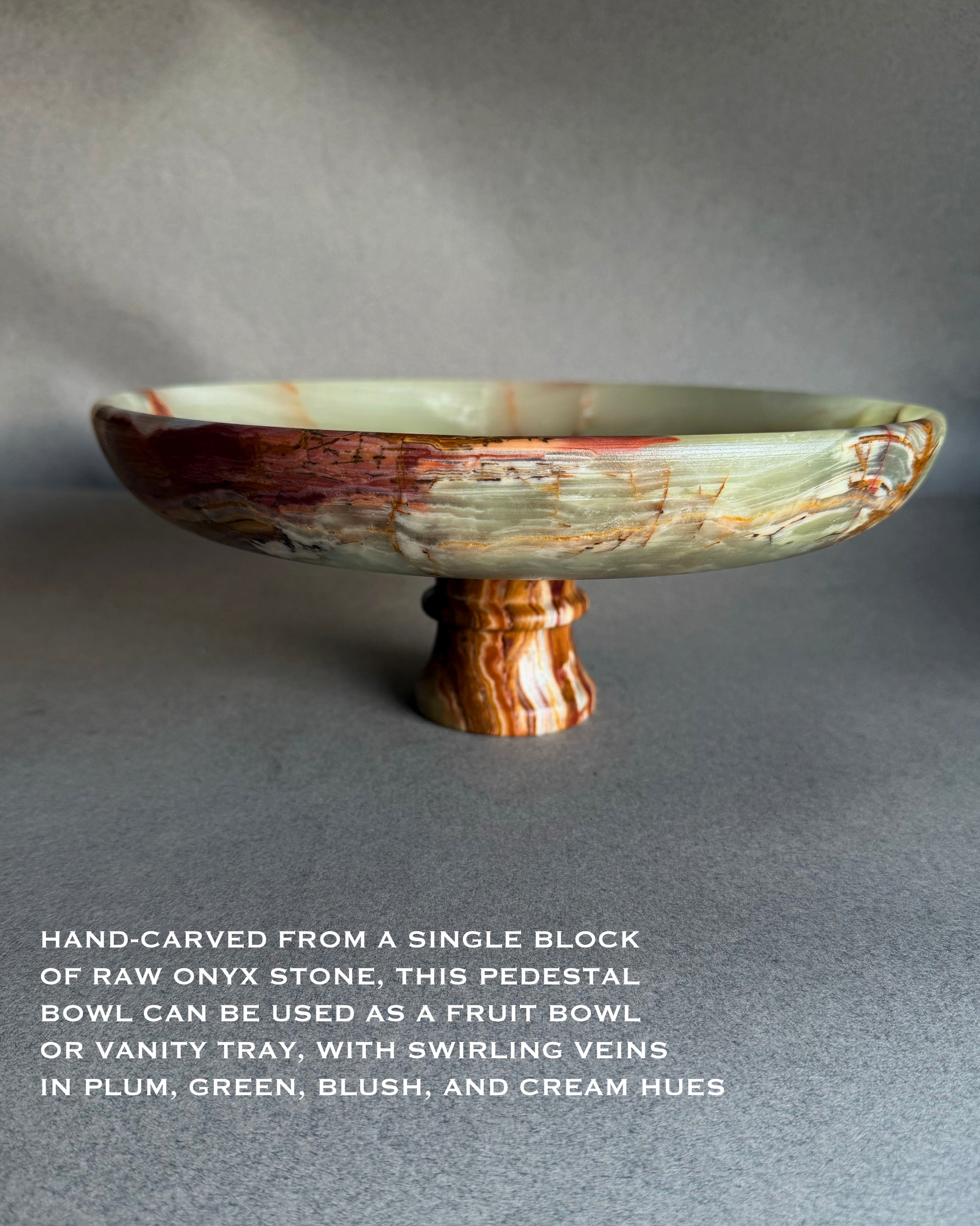 Side profile of sculptural onyx pedestal bowl with layered sage green, rust, plum, and cream banding on pedestal base
