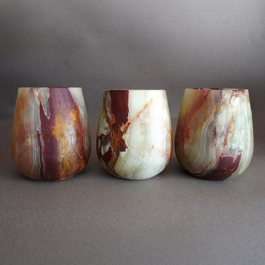 Three marbled stone vessels on a gray background
