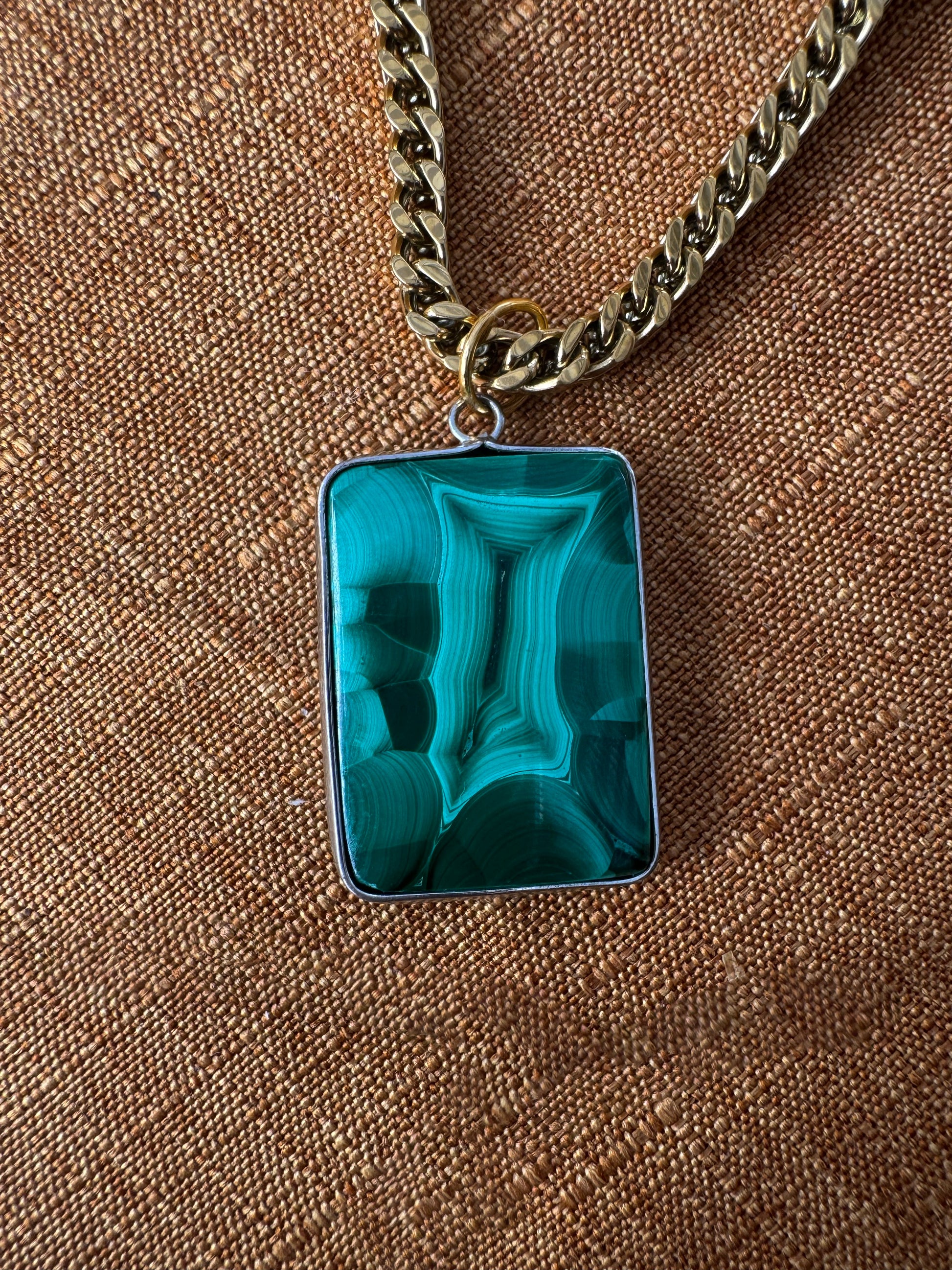 Necklace with a green marbled pendant on a brown textured background