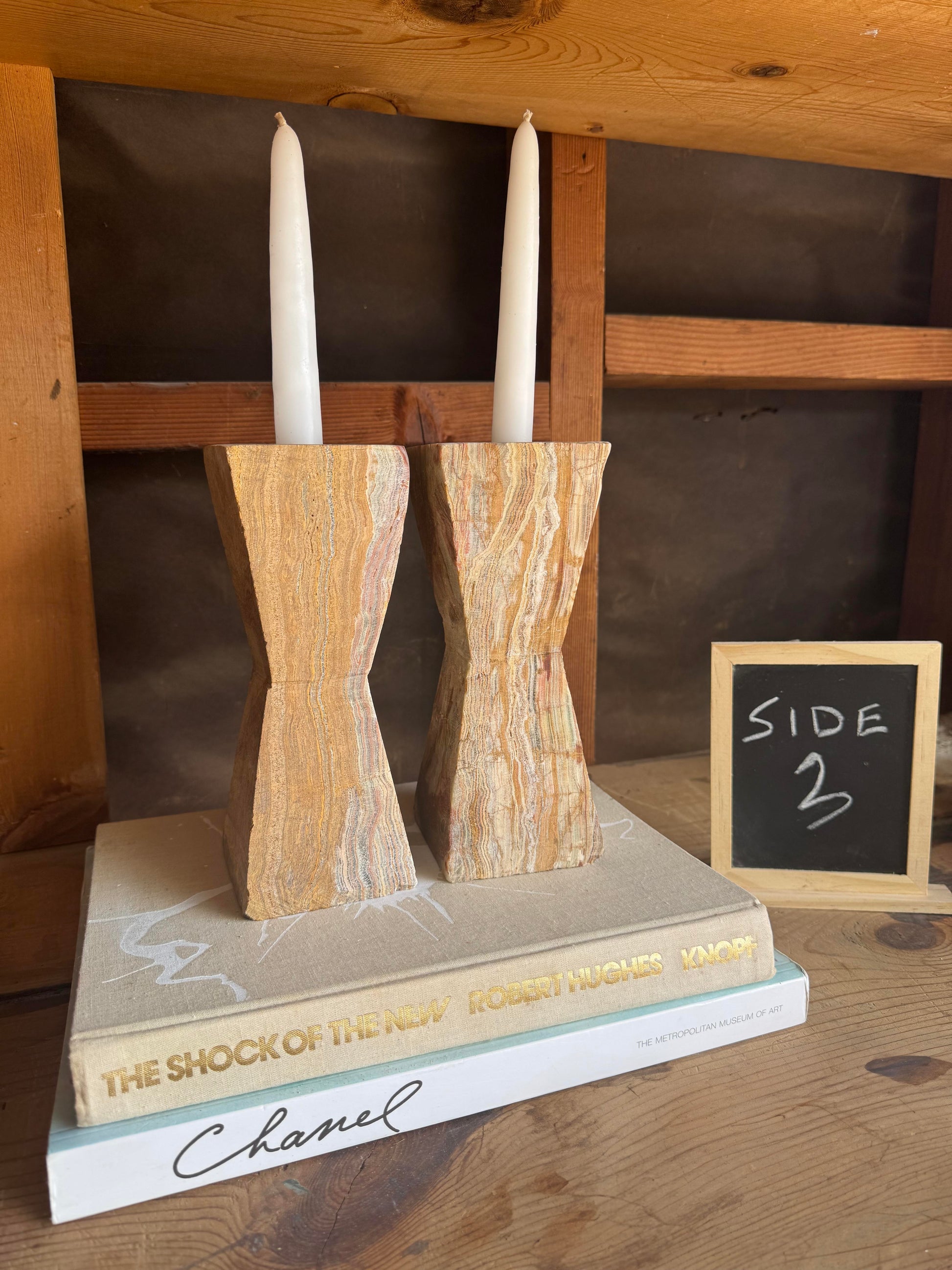 Onyx candle holders in earthy shades of tan, blush, and clay with taper candles lit