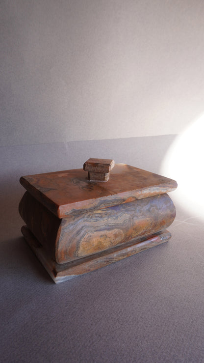 Small decorative stone box with lid, handcrafted from natural onyx for home decor  
