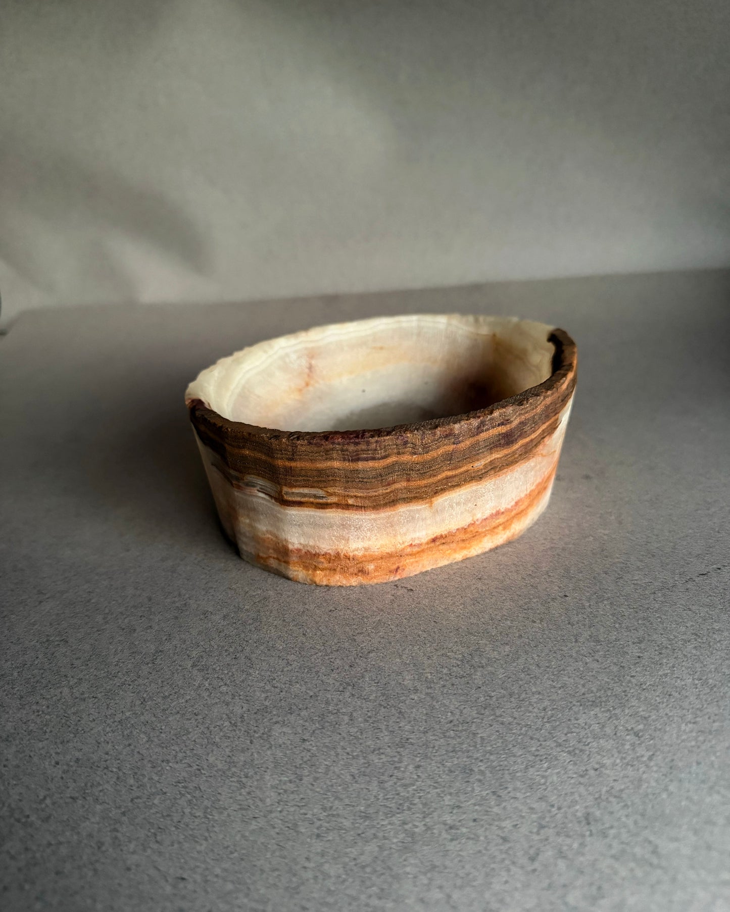 Natural white and brown onyx catchall bowl carved from solid stone with visible raw texture
