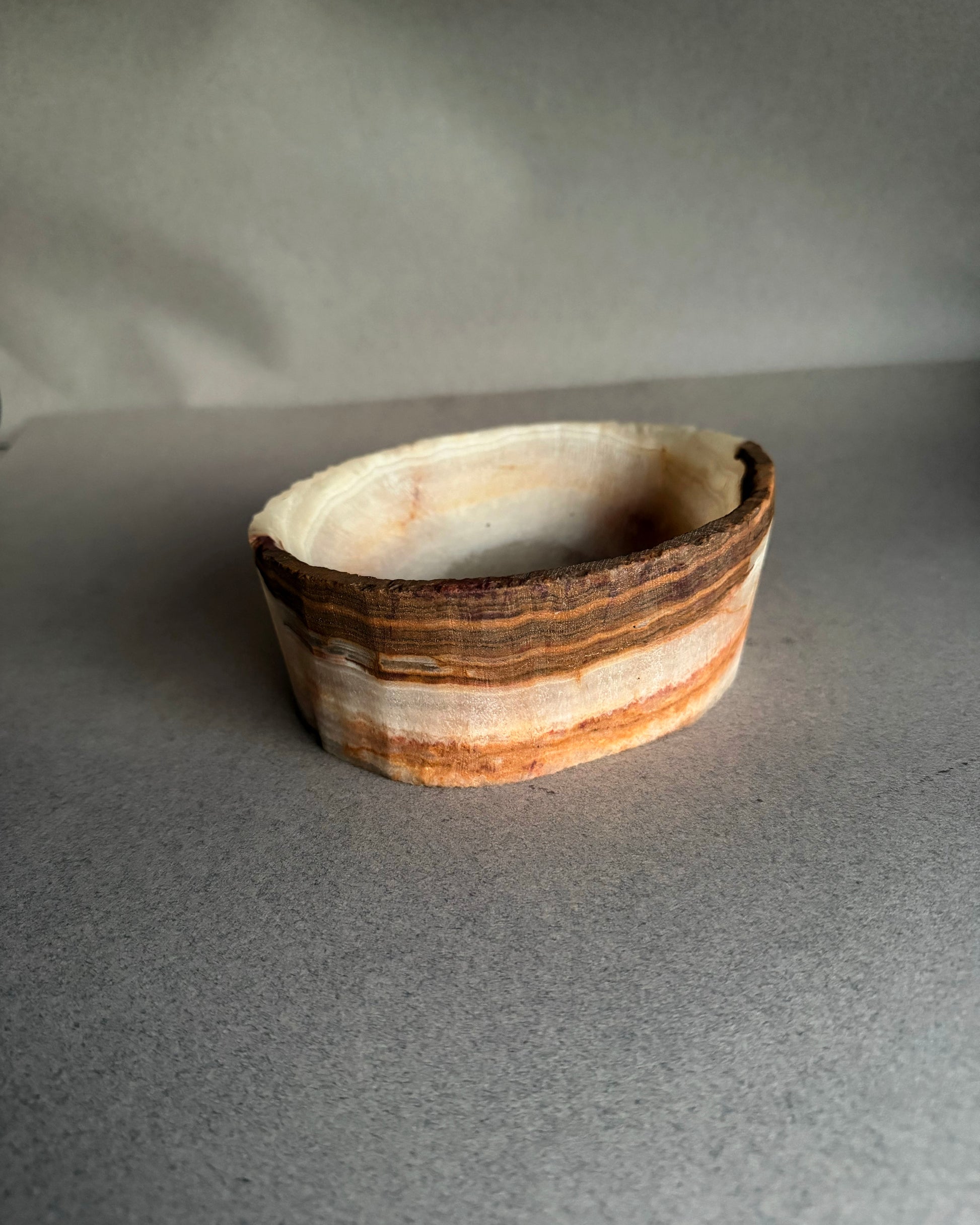 Natural white and brown onyx catchall bowl carved from solid stone with visible raw texture
