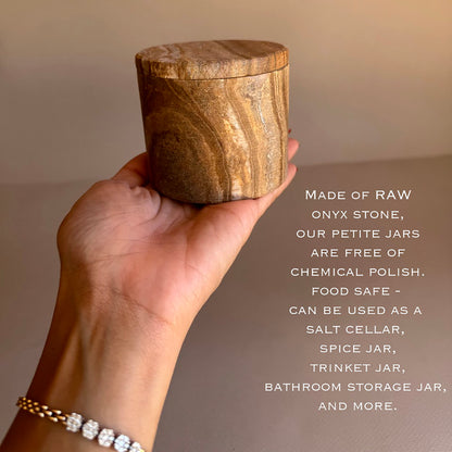 Hand holding a wooden jar with text about its uses and material