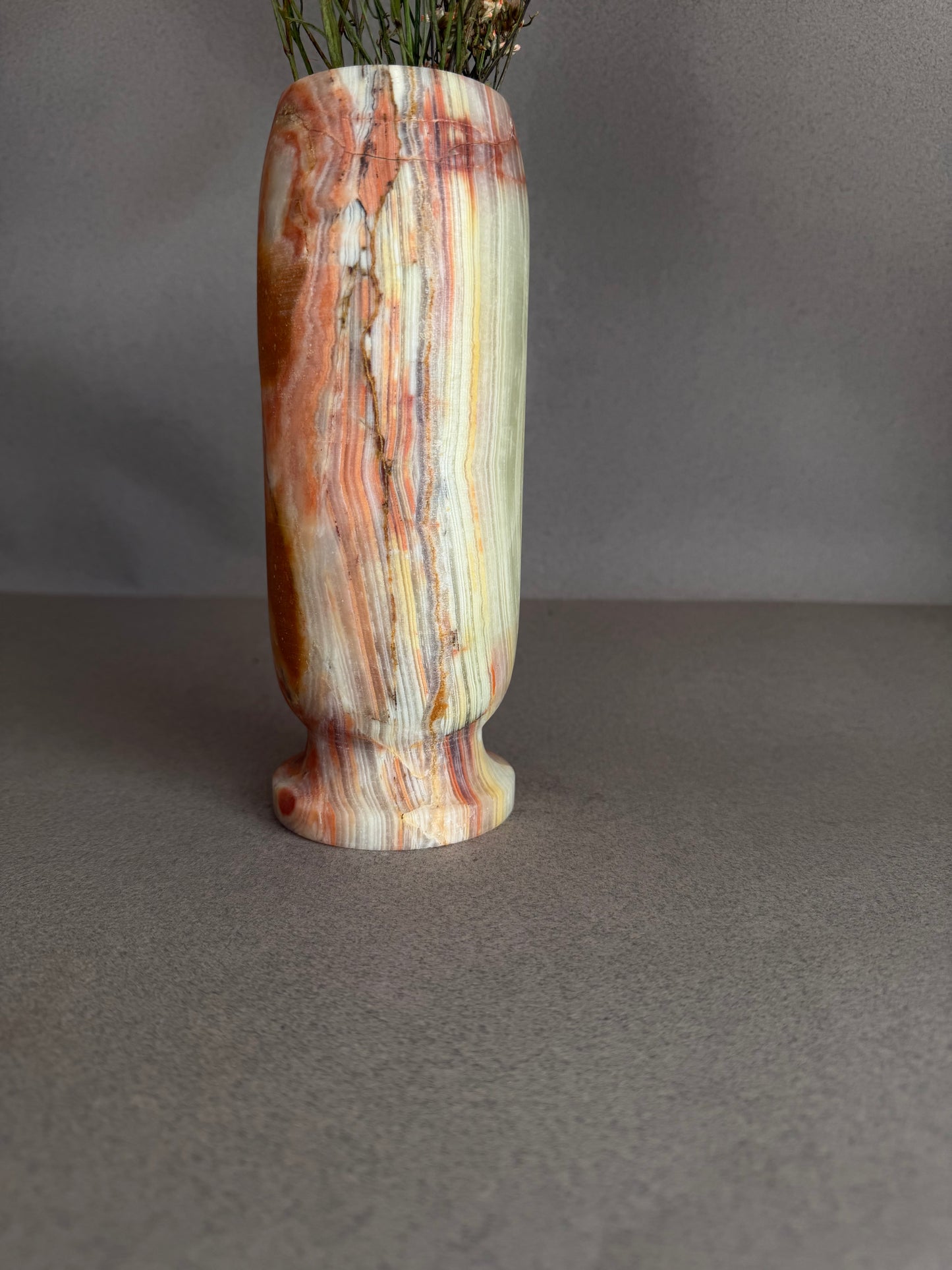 Decorative vase with multicolored stripes on a gray background