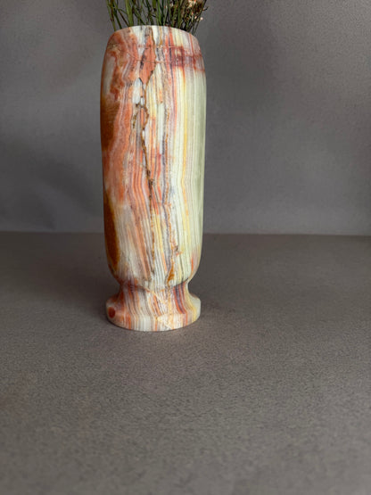 Decorative vase with multicolored stripes on a gray background