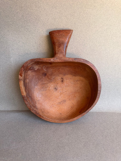Wooden bowl with a handle on a beige background