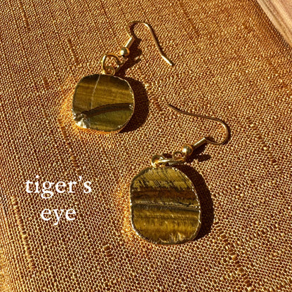 Tiger's eye earrings on a textured gold surface