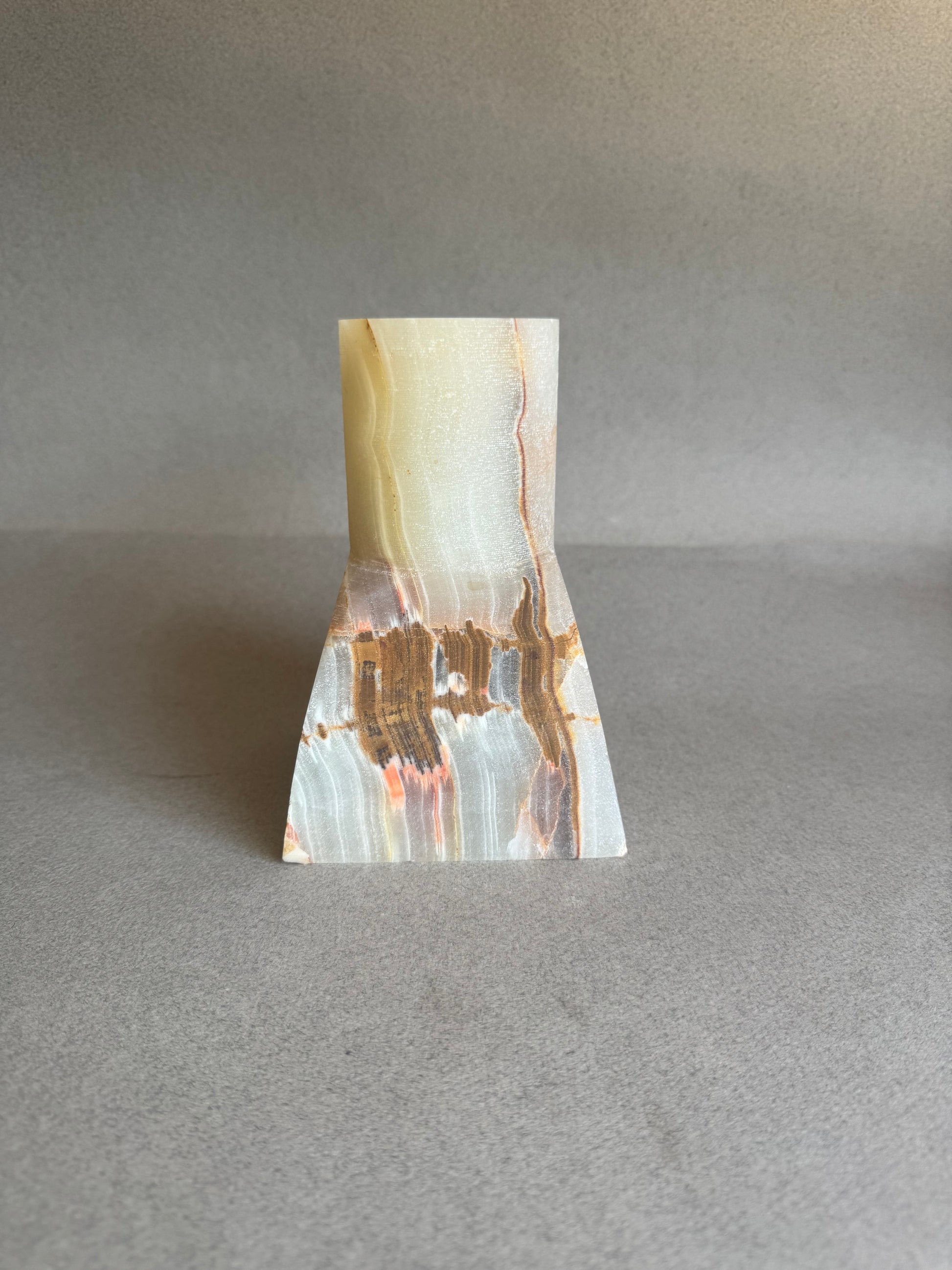 Marble-patterned stone vase on a gray background