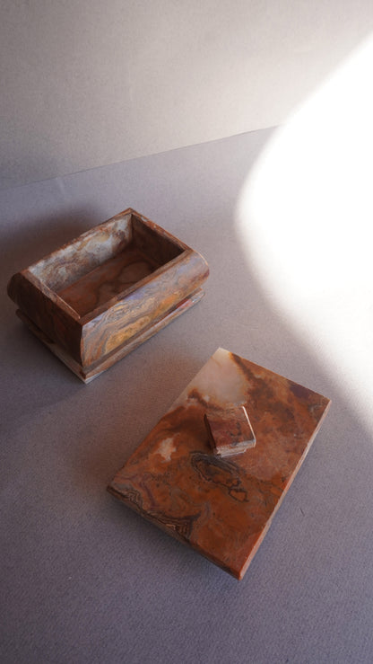 Onyx storage box with removable lid shown beside the base on neutral background  
