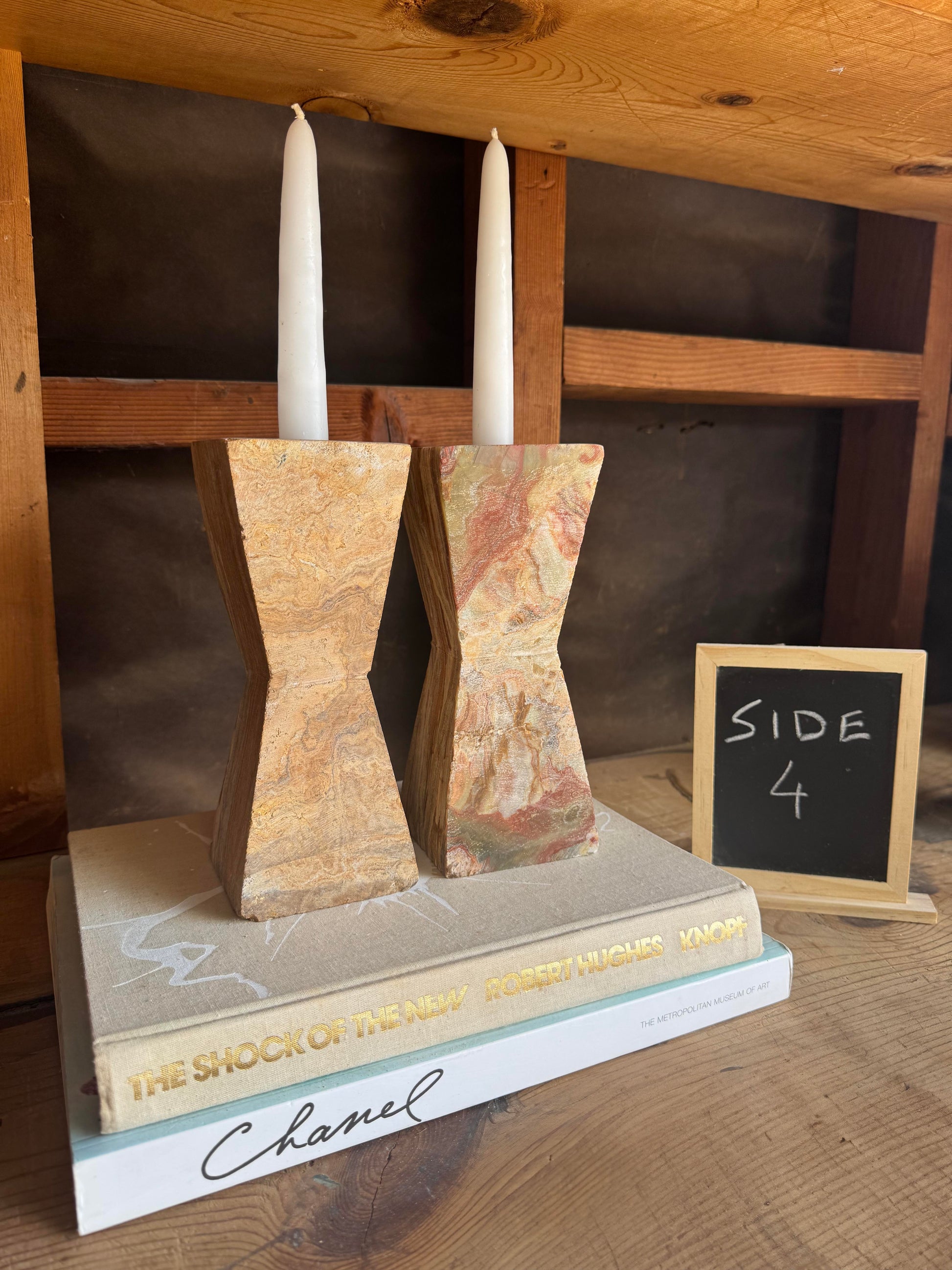 Hand-carved onyx candle holders in warm earth tones – view with taper candles on styled stack of books