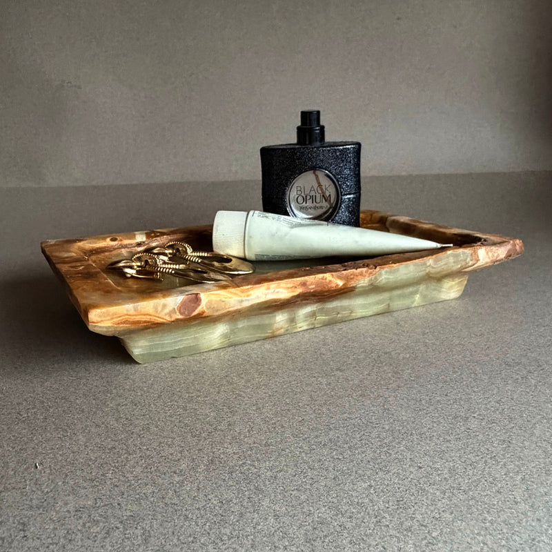 Side view of unpolished onyx vanity tray showing natural banding and raw stone edges
