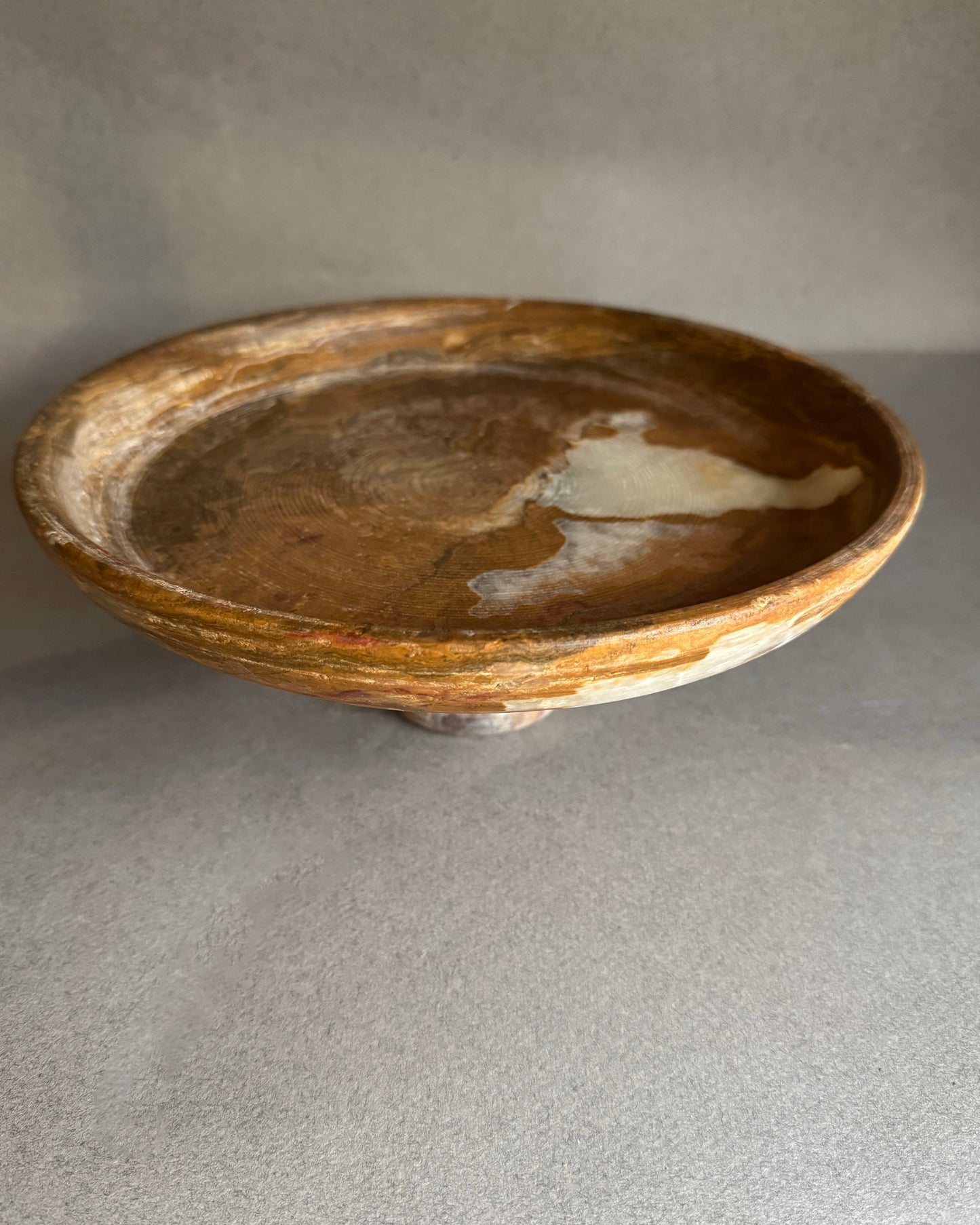 Brown ceramic bowl on a gray surface with a neutral background