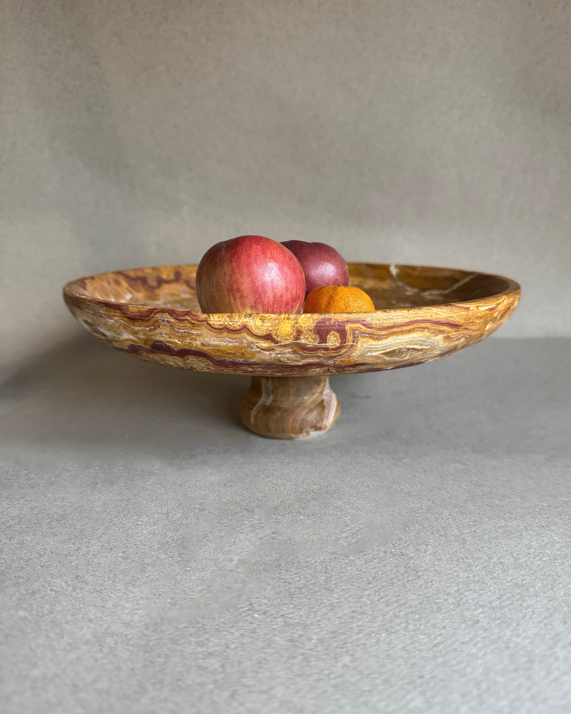 Stone bowl with apples on a gray surface