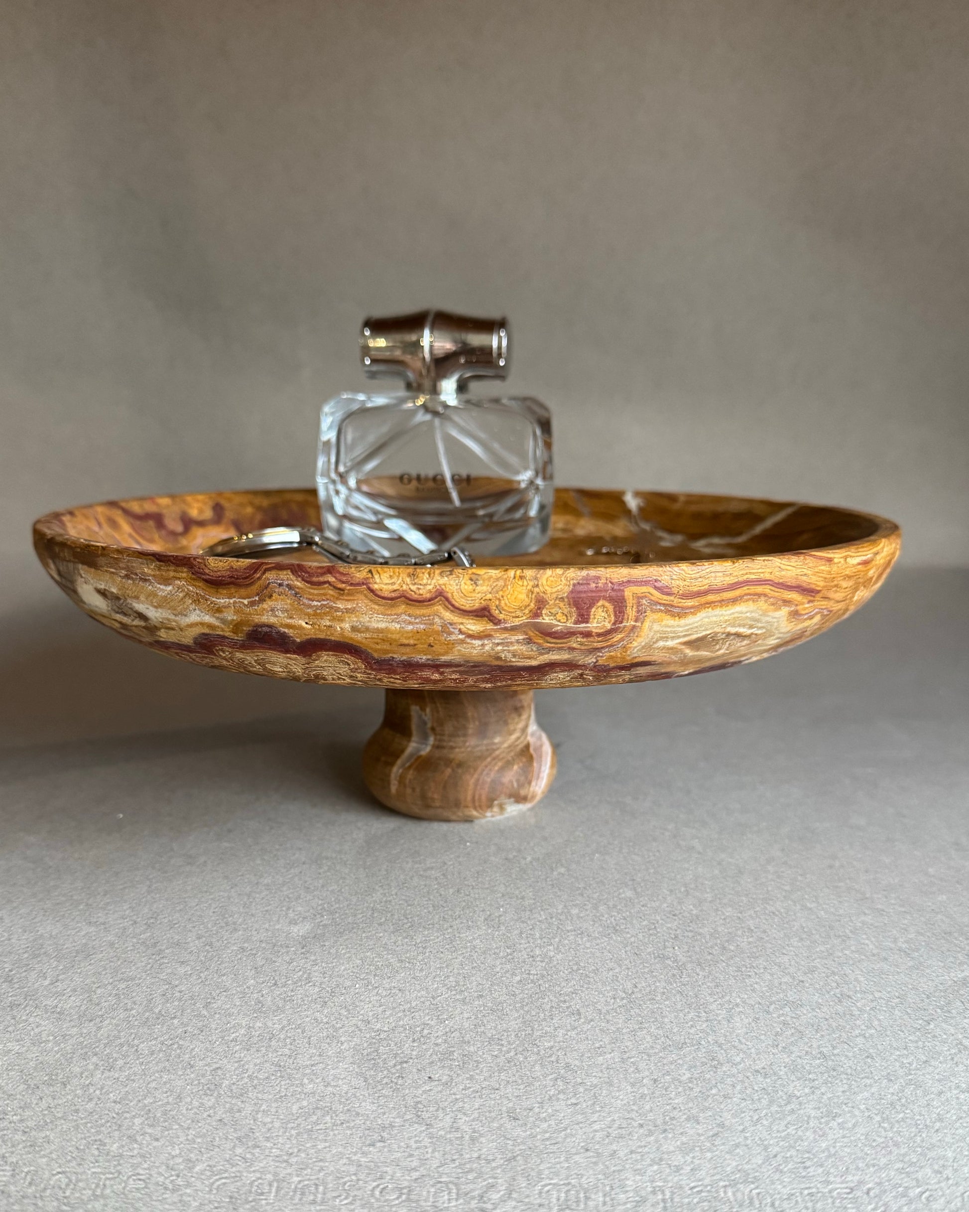 Decorative stone bowl with a glass container on a neutral background
