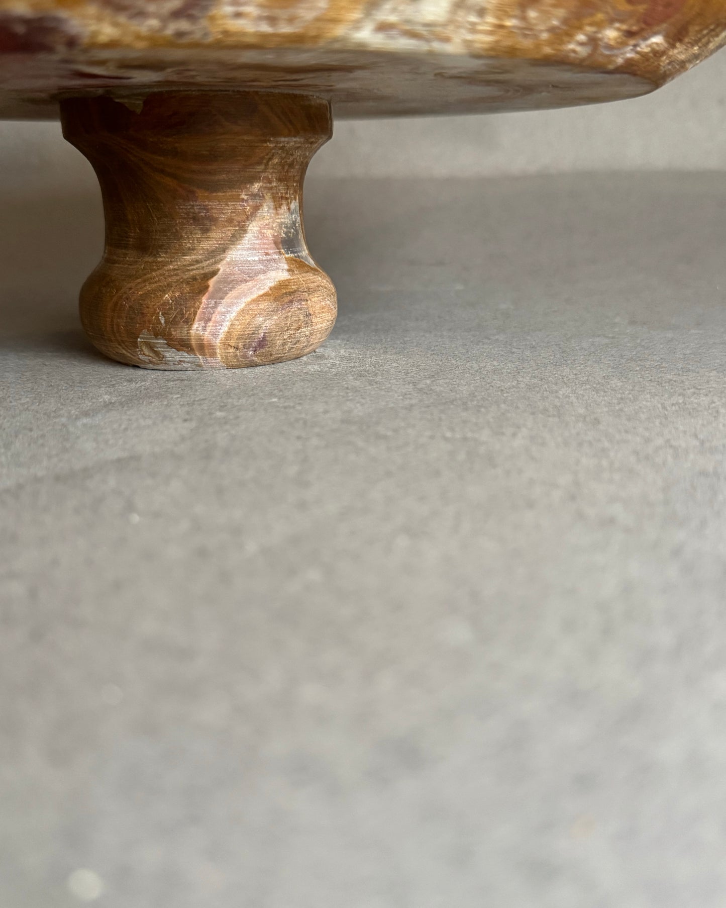 Onyx stone pedestal stand on a gray surface