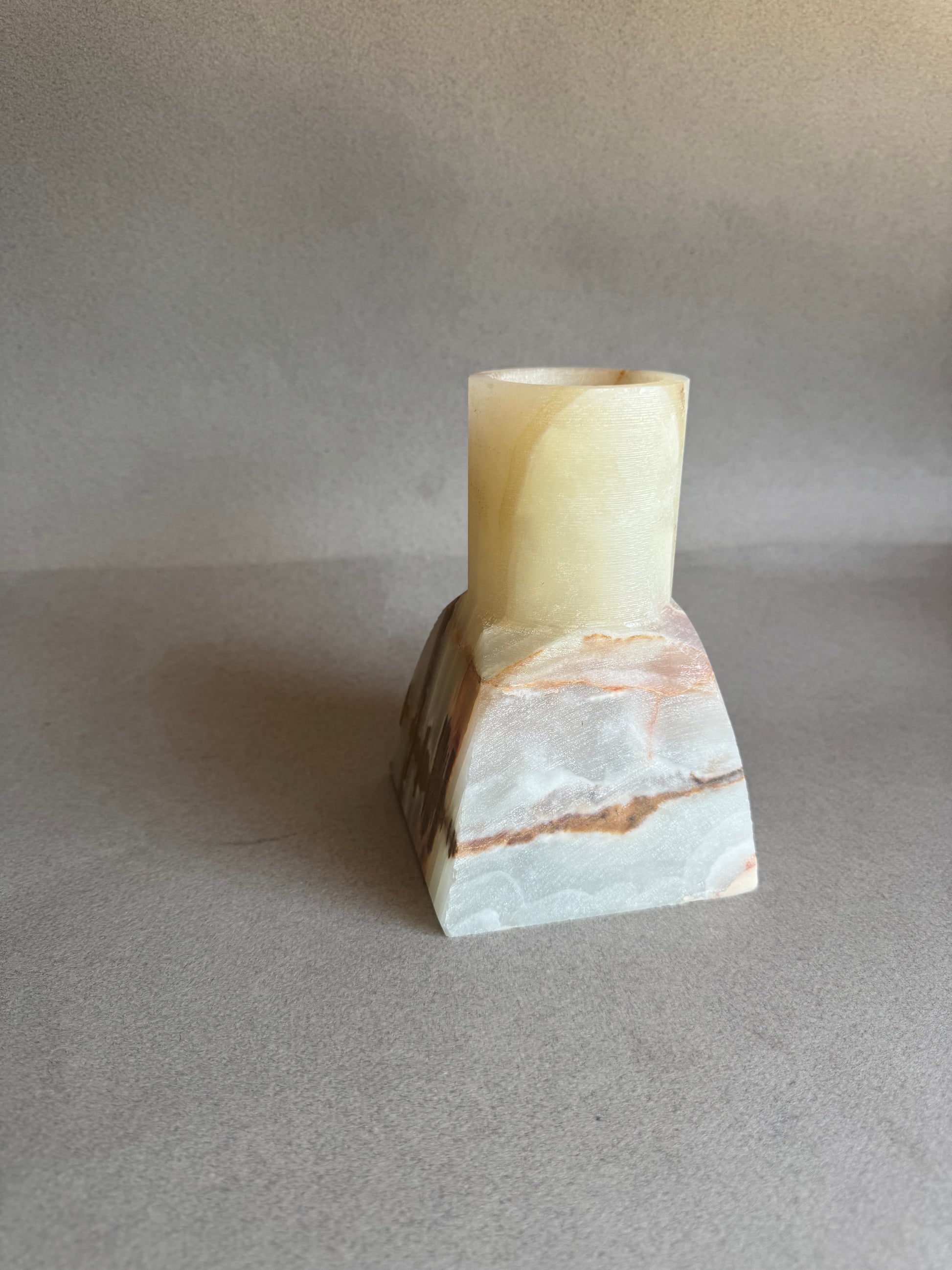 Marble-textured cylindrical vase on a gray background