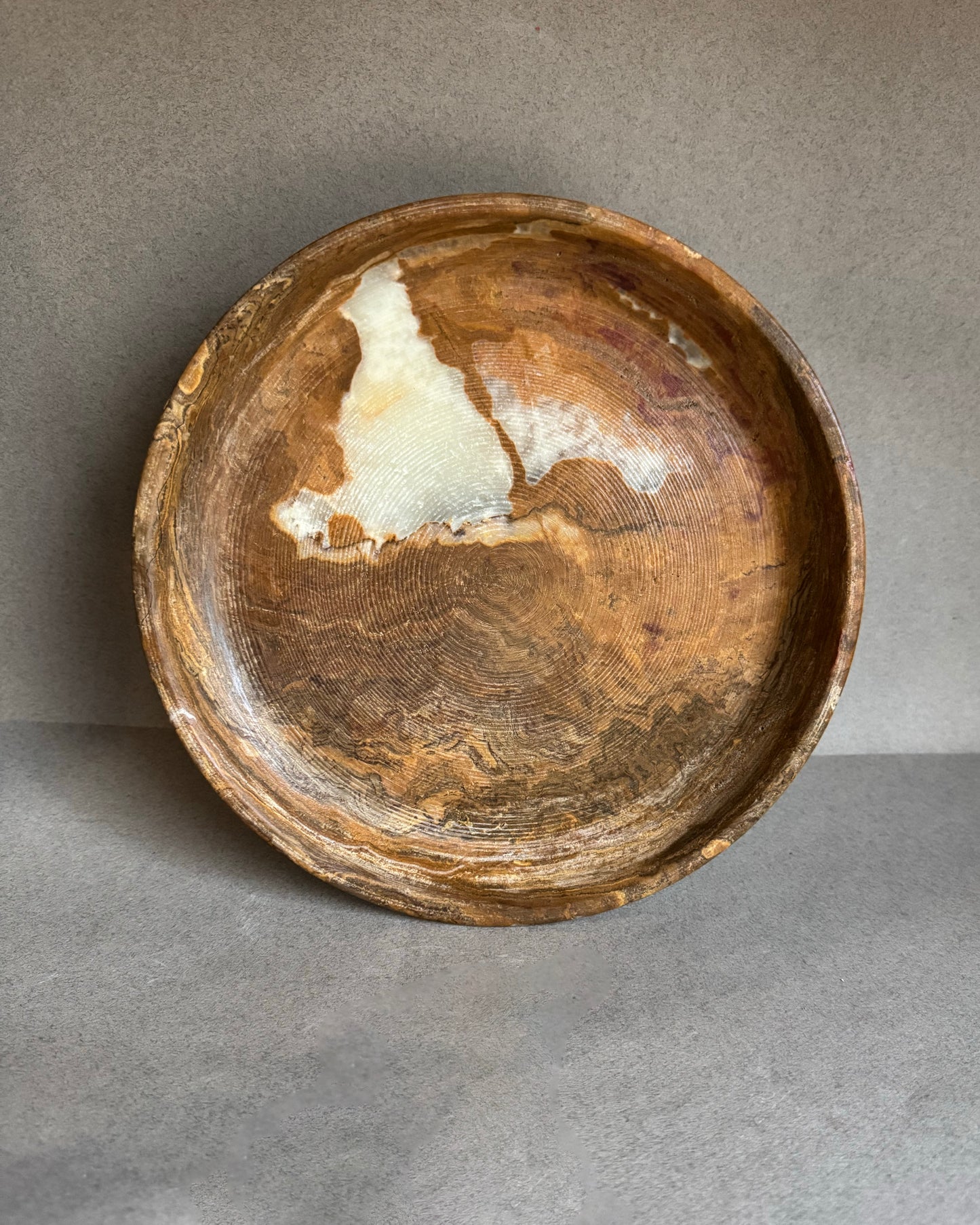 Top view of onyx pedestal bowl showing cream and walnut veining, unique marbled natural stone fruit bowl and centerpiece dish.
