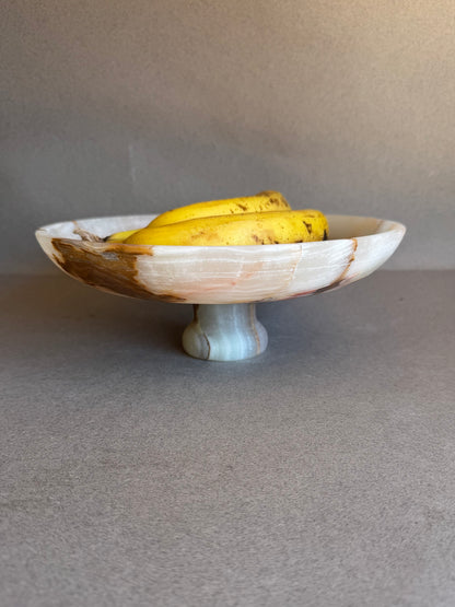 Onyx pedestal bowl holding bananas, showing function as fruit stand