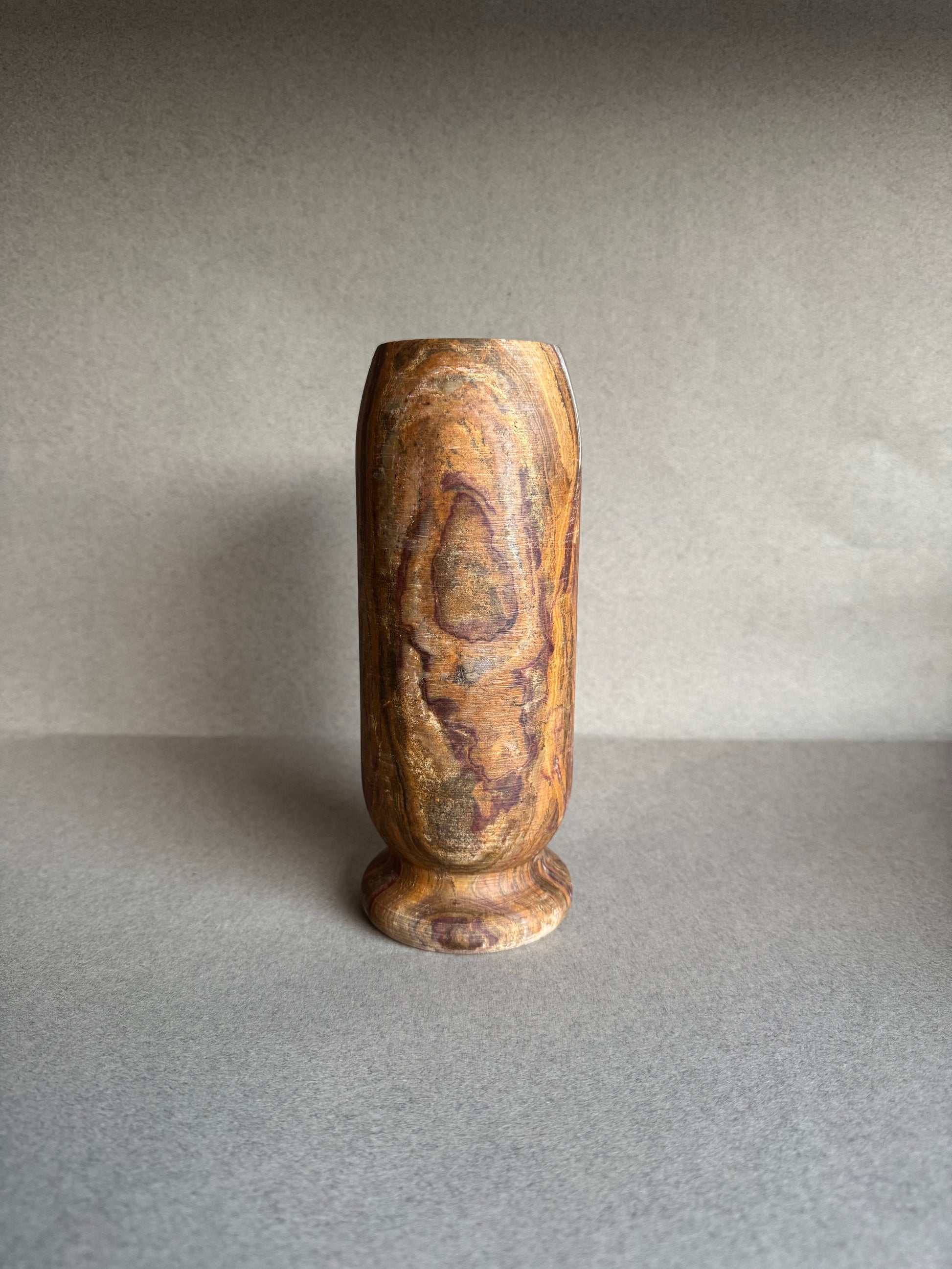 Earth-toned onyx vase with striated veining and rounded base