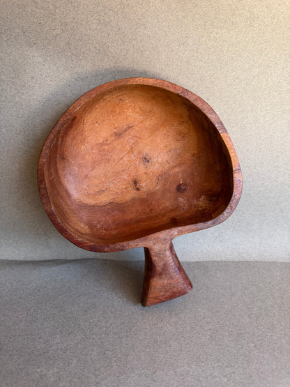 Brown wood bowl with a handle on a gray background