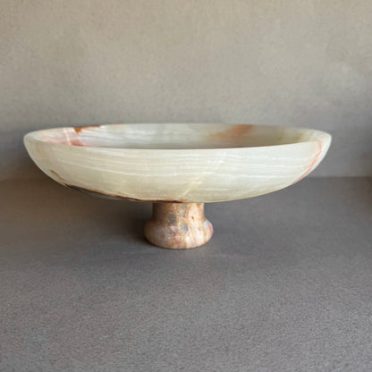 Onyx pedestal bowl glowing with natural light, showing depth and layered veining