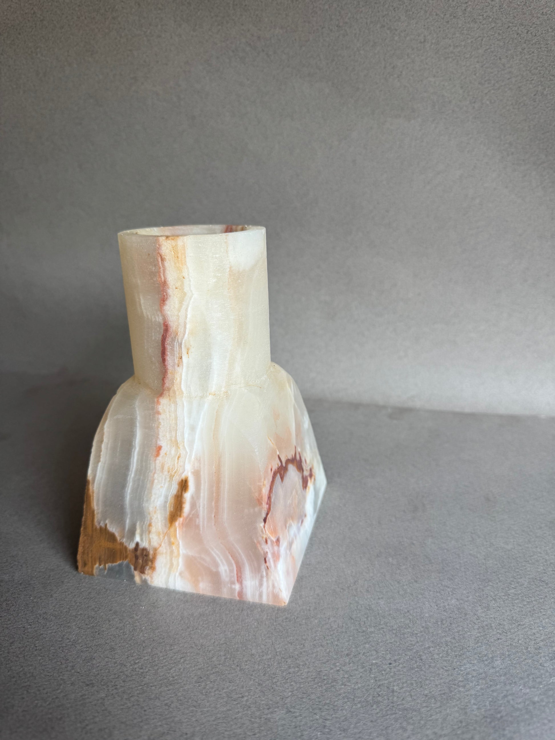 Polished onyx stone with veining on a gray background