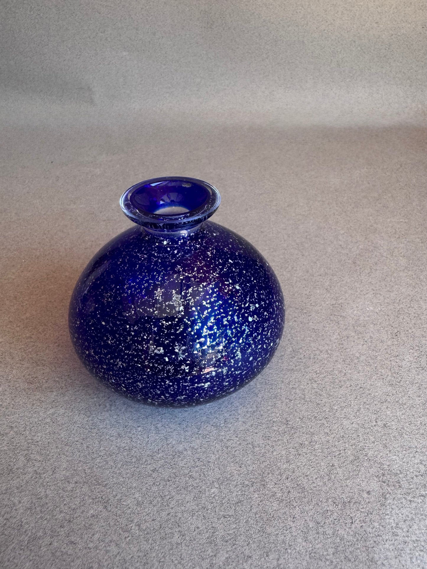 Blue speckled vase on a gray background
