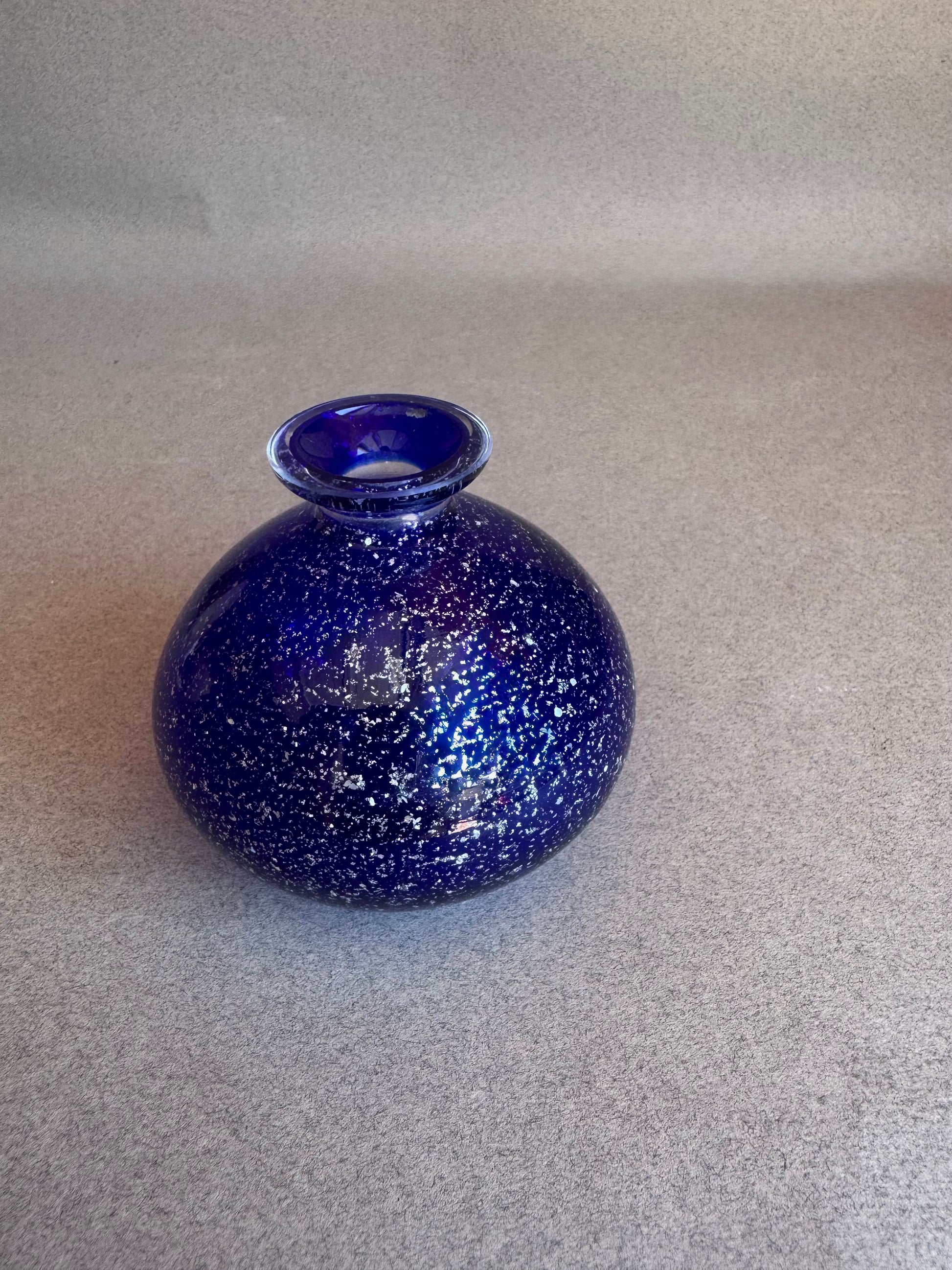 Blue speckled vase on a gray background