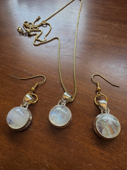 Jewelry set with moonstone pendant and earrings on a wooden surface