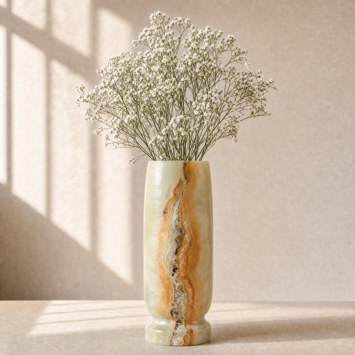 Decorative vase with wavy pattern containing small white flowers on a neutral background