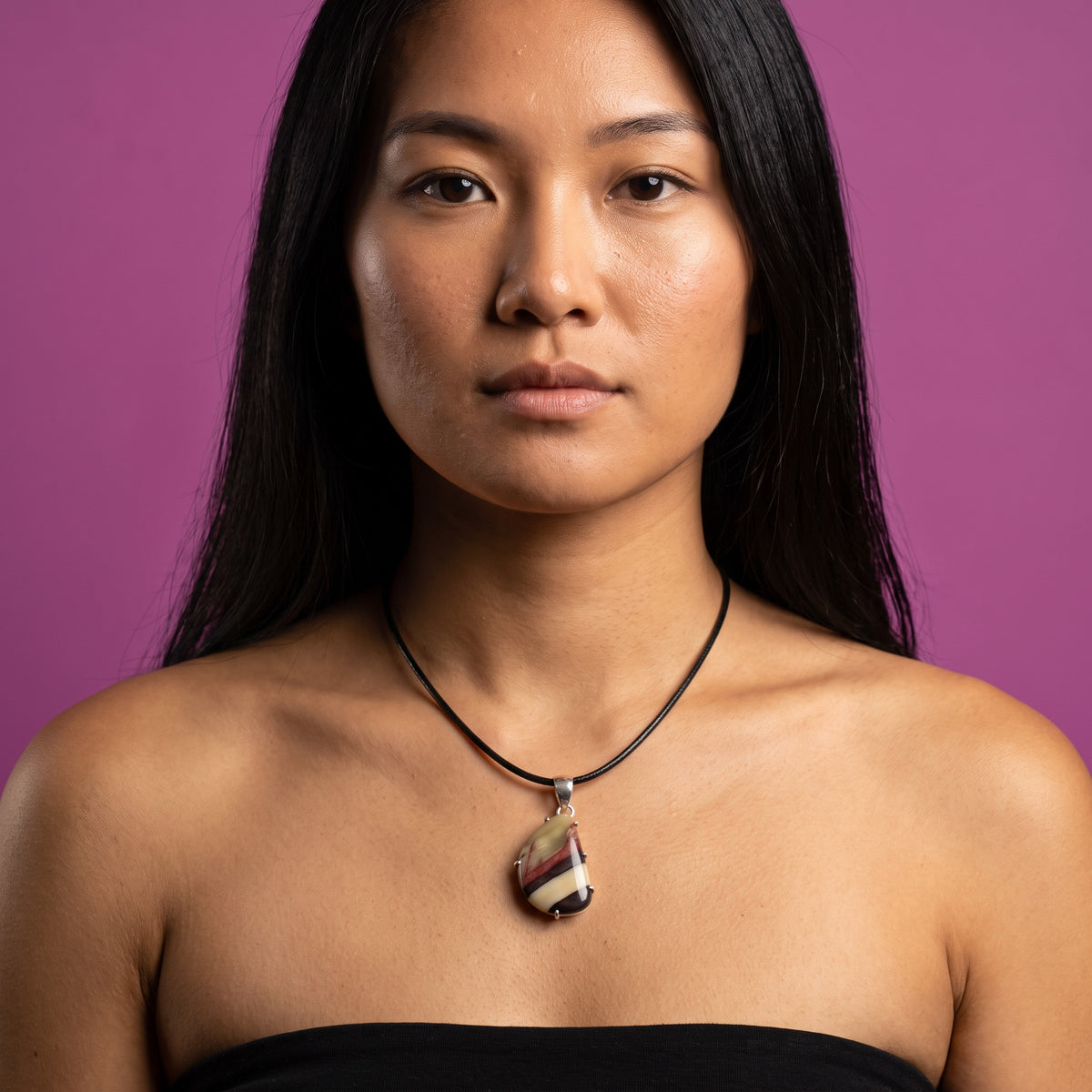 Mookaite jasper freeform pendant on a short black leather cord, cream, rose and plum bands in a six-prong sterling silver setting