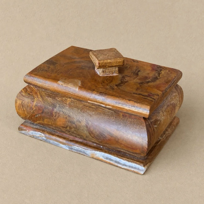A handcrafted brown stone marble box with a lid, featuring rich brown and golden wood grain patterns, set against a solid beige background.