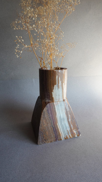 Close-up of a stone vase with a textured surface on a gray background