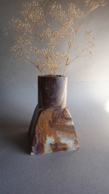 Decorative onyx vase with marbled pattern on a neutral background