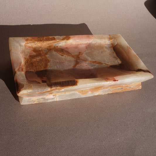 Rectangular stone dish with brown and beige patterns on a beige background