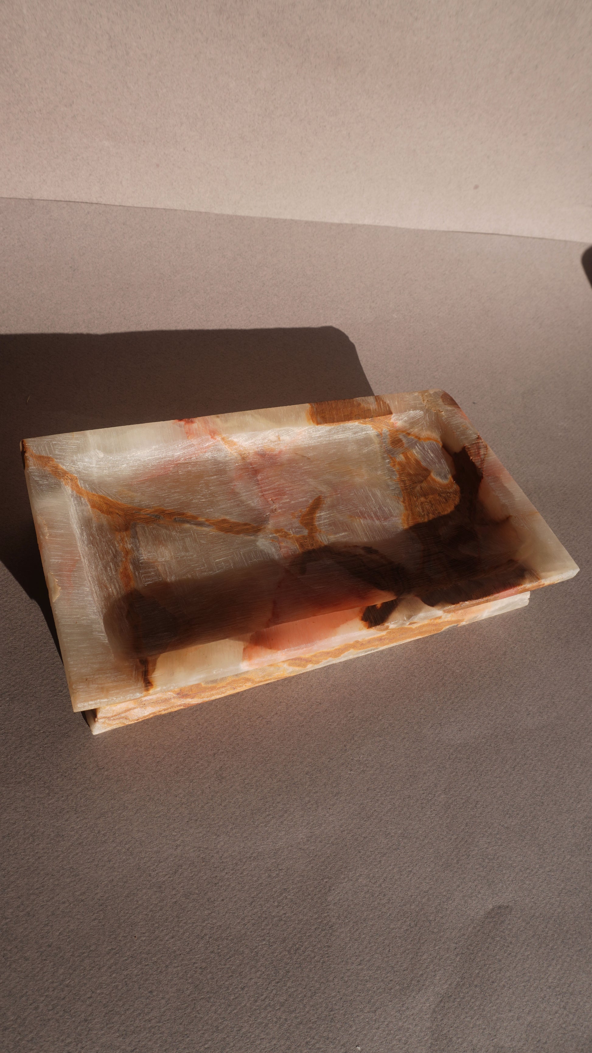 Rectangular onyx stone tray with brown and beige patterns on a plain background