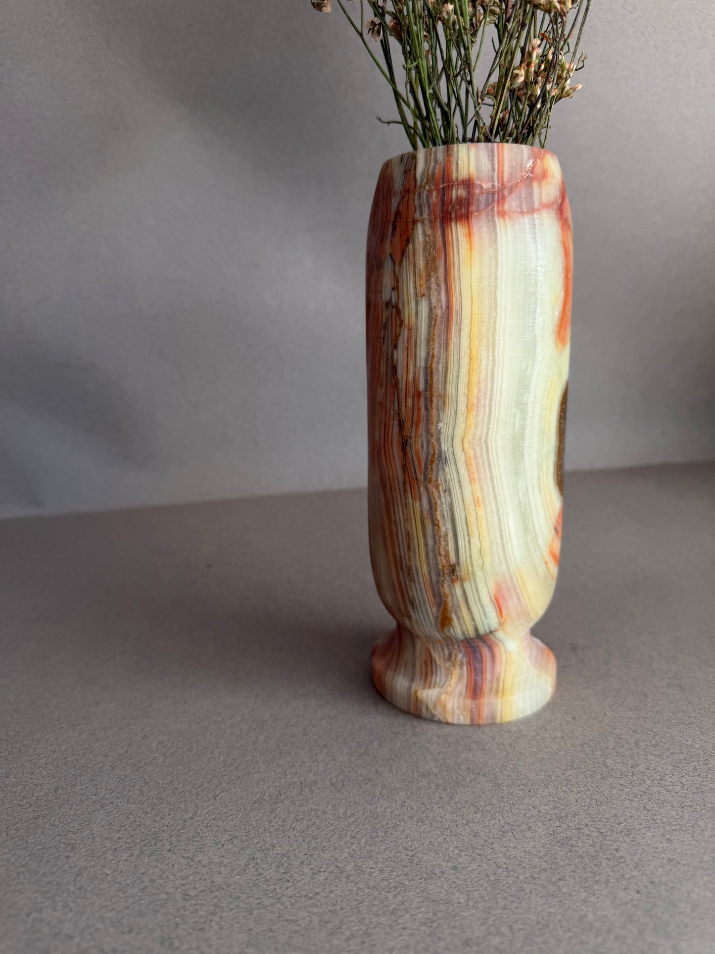 Decorative vase with multicolored striped design on a plain background