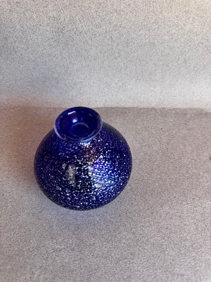 Blue speckled vase on a gray surface