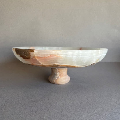 Side view of sculptural onyx bowl with warm light revealing its semi-translucent quality.