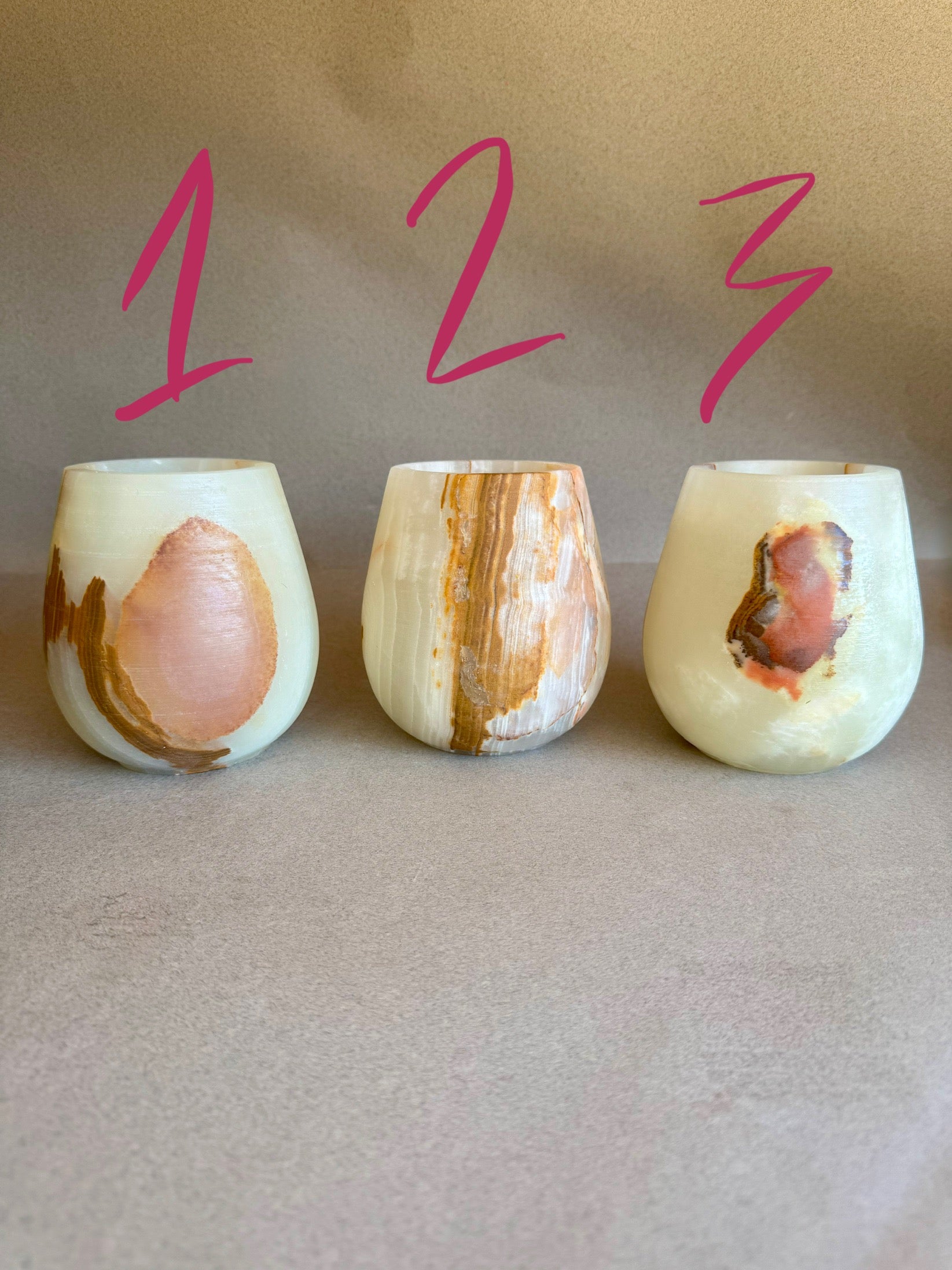 Three pink onyx vessels with natural patterns on a beige background, labeled 1, 2, and 3.