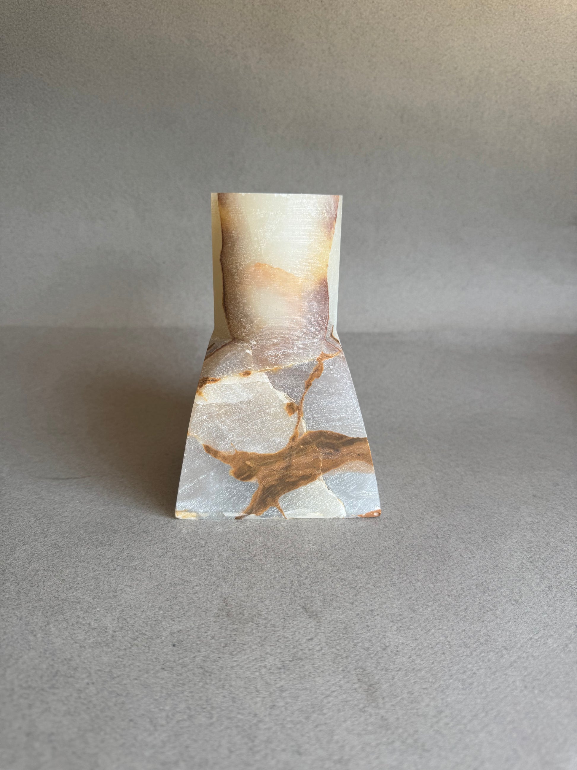 Marble-patterned stone vase onyx tie on a gray background
