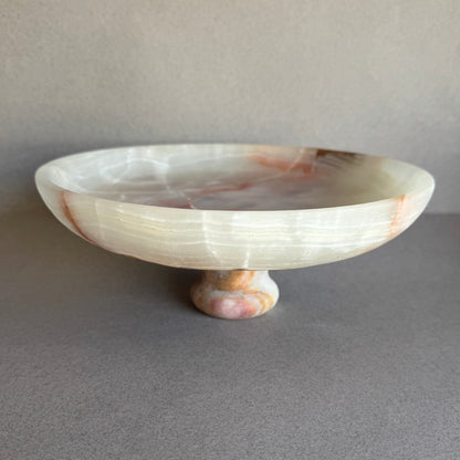 Onyx pedestal bowl glowing with natural light, showing depth and layered veining