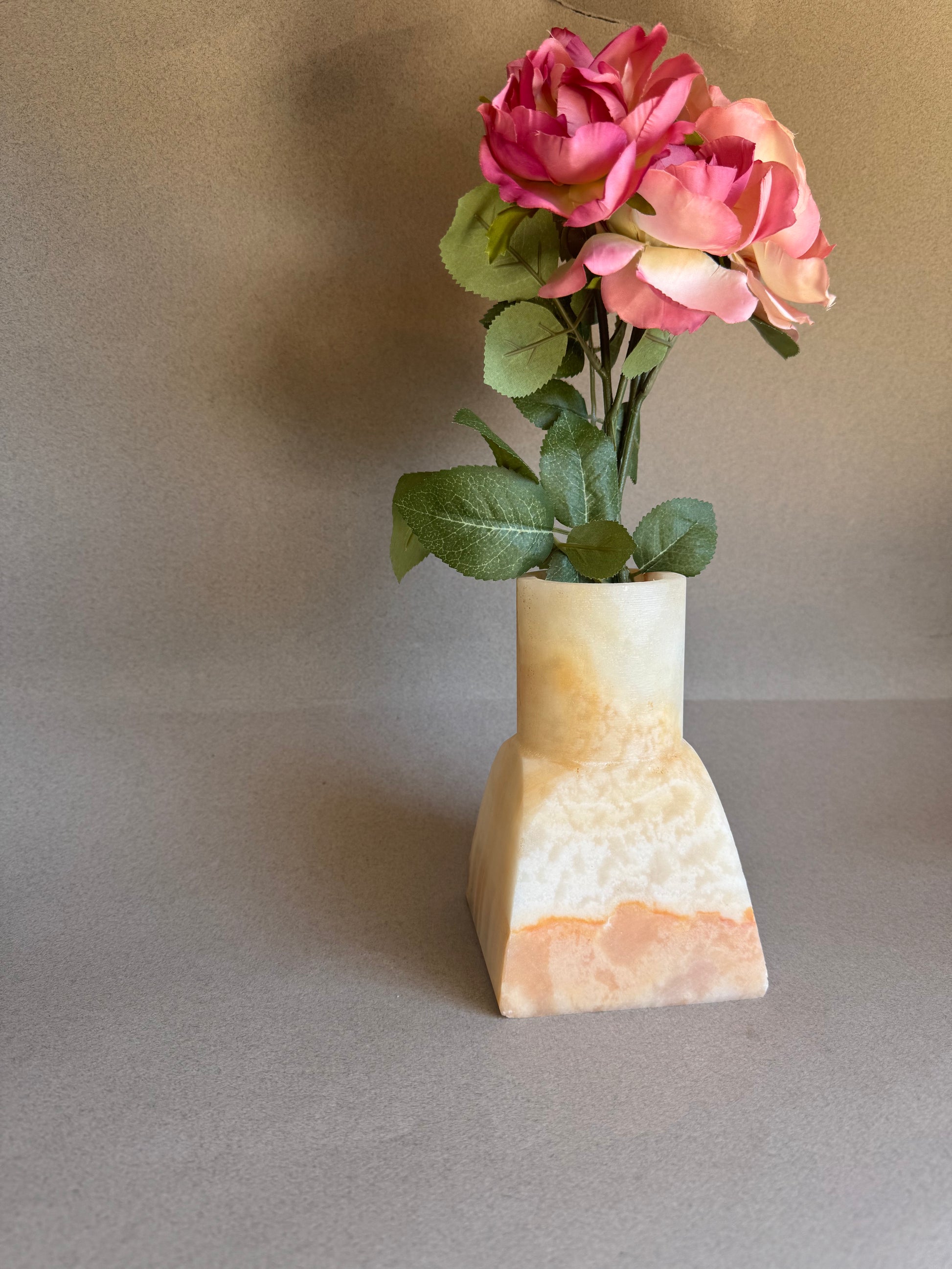 pink onyx Vase with pink flowers on a gray background