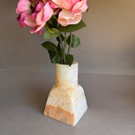 Decorative PINK ONYX vase with pink flowers on a neutral background