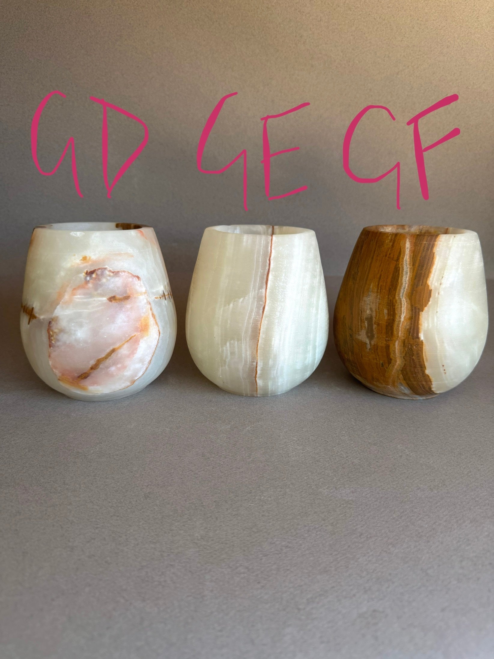 Three onyx cups with marbled patterns on a gray background, with 'GD GE GF' text above.