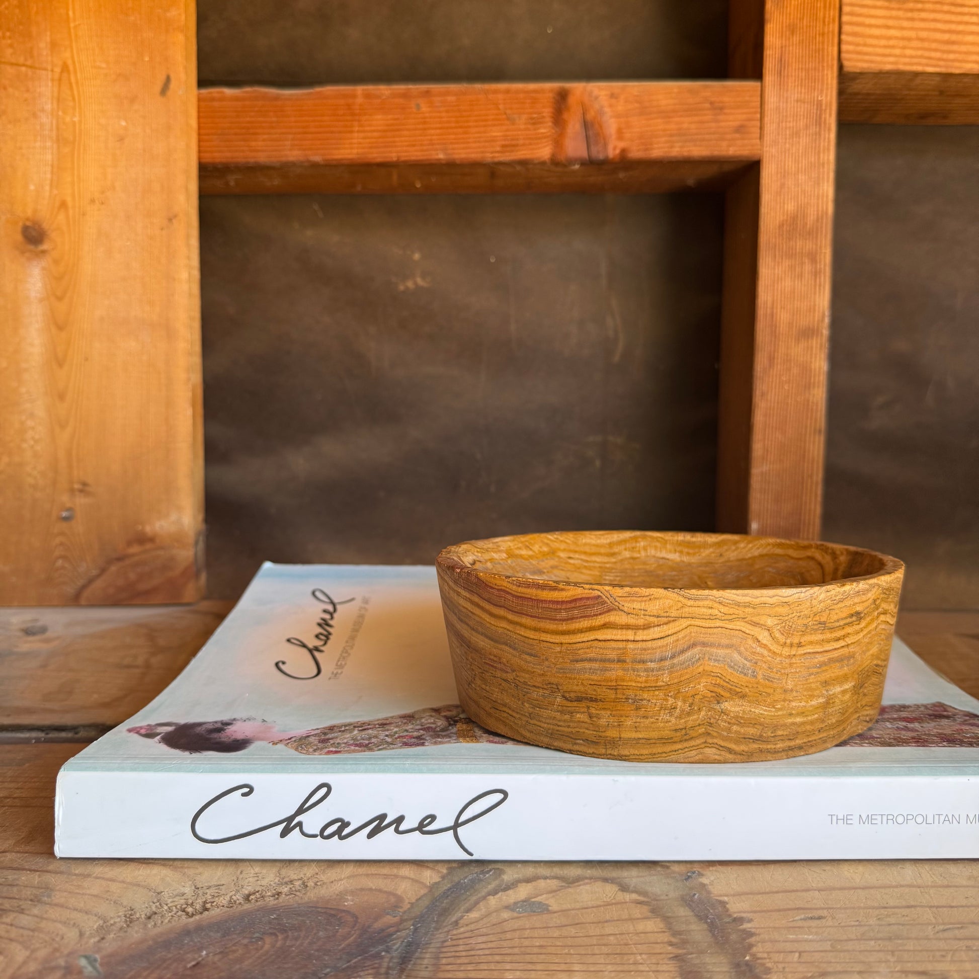 Canyon-toned onyx bowl displayed as a jewelry holder, emphasizing its natural texture and striated grain


